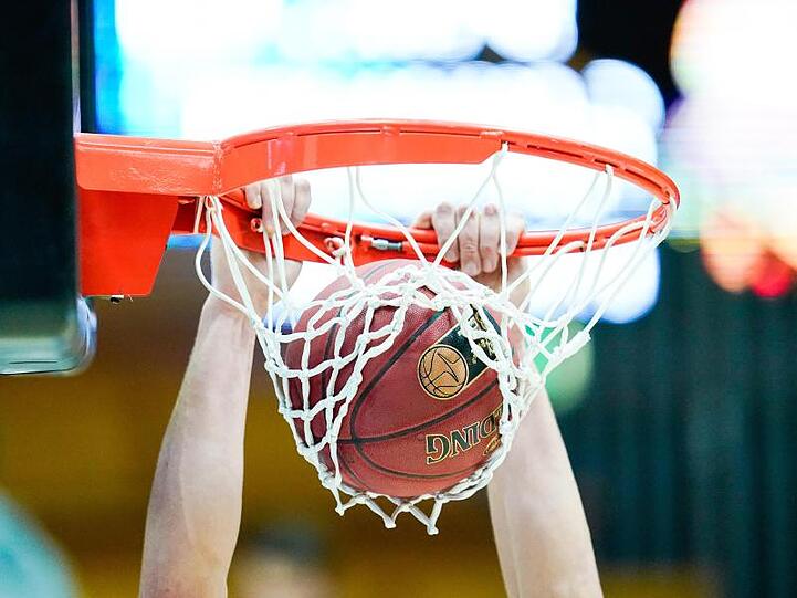 Ein Basketballspieler wirft den Ball in den Korb. Foto: Uwe Anspach/dpa/Archivbild/Symbolbild