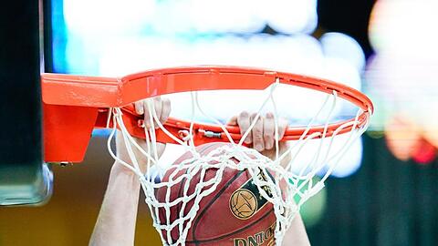 Ein Basketballspieler wirft den Ball in den Korb. Foto: Uwe Anspach/dpa/Archivbild/Symbolbild