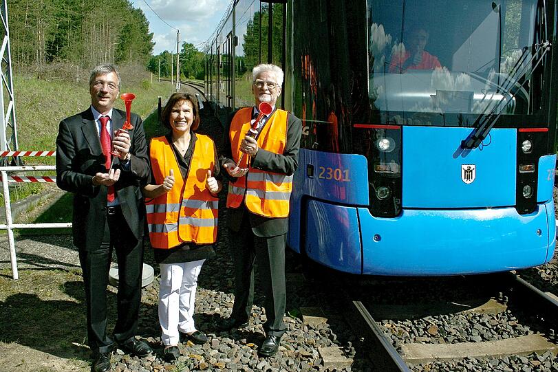 Michael Daum von der Hersteller-Firma Stadler Pankow, die Veltener Bürgermeisterin Ines Hübner und MVG-Chef Herbert König posieren vor der Akku-Tram.