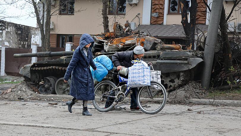 Zivilisten gehen an einem Panzer vorbei, der bei schweren Kämpfen in einem von den von Russland unterstützten Separatisten kontrollierten Gebiet in Mariupol zerstört wurde.