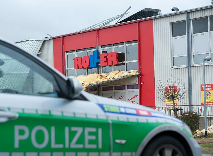 Ein Polizeifahrzeug steht am Donnerstag (05.01.2012) in Regensburg (Oberpfalz) vor einem vom Sturm abgedeckten Möbelhaus.