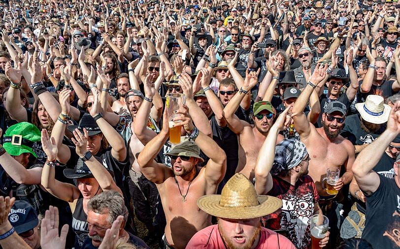Festivalbesucher laufen in der gleißenden Sonnen über die sich langsam füllenden Zeltplätze. Die traditionelle Schlammschlacht ist bislang ausgeblieben, es droht eine Hitzeschlacht.