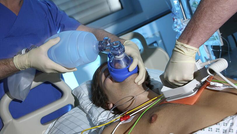 Ein Patient auf einer Intensivstation wird von Hand beatmet. Erfunden wurde diese Methode 1952 vom dänischen Anäthesisten Björn Ibsen.