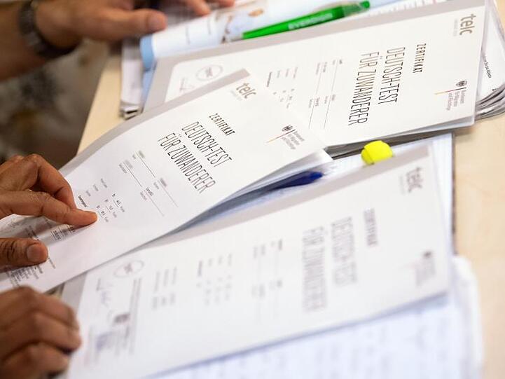 Kursteilnehmer freuen sich über ihre Zertifikate "Deutsch-Test für Zuwanderer". Foto: Sven Hoppe
