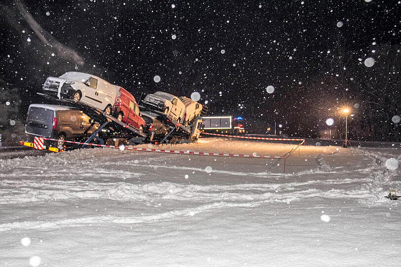 Ein Autotransporter rutscht aufgrund der schneeglatten Fahrbahn in den Graben