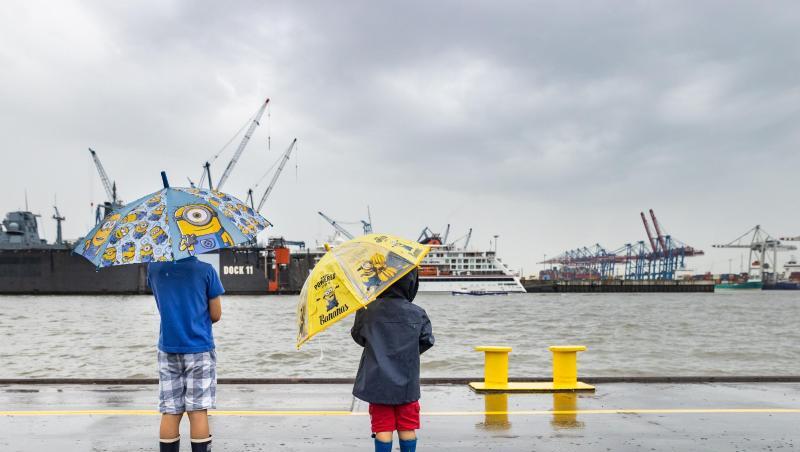 Mit bunten Regenschirmen schützten sich zwei Jungen im Hafen Hamburg vor dem Regen. Nach vielen trockenen, sonnigen Tagen regnet es wieder in der Hansestadt. Mit bunten Regenschirmen schützten sich zwei Jungen im Hafen Hamburg vor dem Regen. Nach vielen trockenen, sonnigen Tagen regnet es wieder in der Hansestadt.