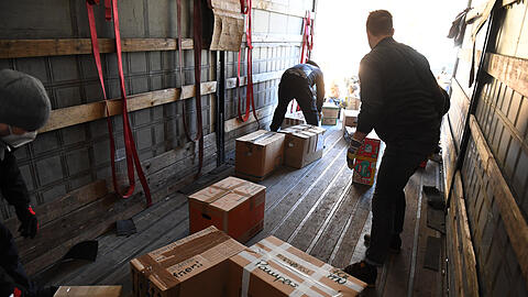 Helfer laden Hilfsgüter und Spenden in einen Lkw.