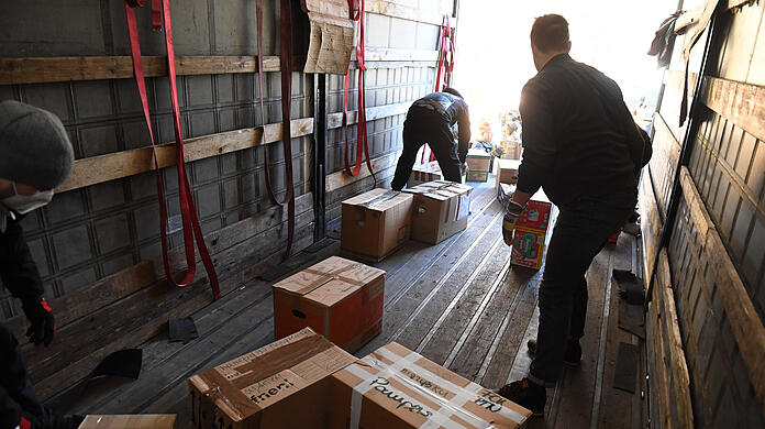 Helfer laden Hilfsgüter und Spenden in einen Lkw.