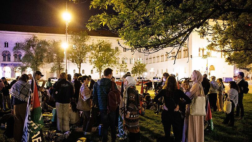 Teilnehmer eines Pro-Palästina-Protestcamps stehen vor der Ludwig-Maximilians-Universität.