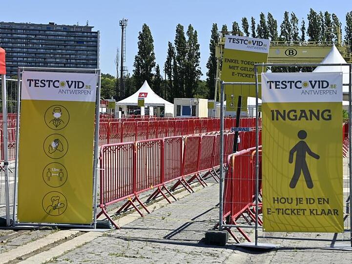 Schilder weisen auf eine Corona-Testanlage an der Veranstaltungsstätte "Spoor Oost" in Antwerpen hin.