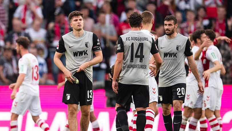 Augsburgs Elvis Rexhbecaj (l-r), Julian Baumgartlinger und Daniel Caligiuri nach der Partie gegen den 1. FC Köln.