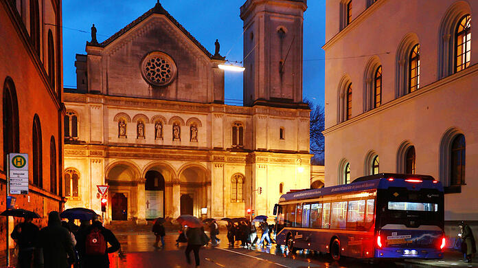 Blaue Stunde mit rotem Rücklicht und hell angestrahlter Ludwigskirche.