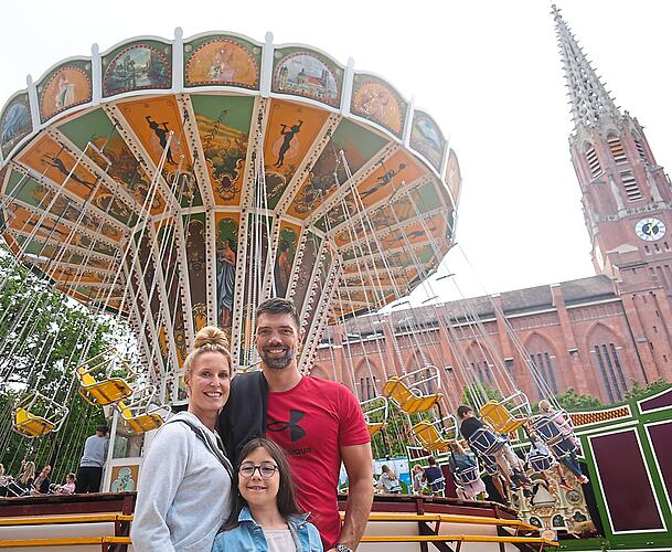 Familie Bendres am Kettenkarussell – Sohn Leo fährt gerade mit. Sie finden am Sonntag besonders angenehm, dass es nicht zu voll ist auf der Dult. Familie Bendres am Kettenkarussell – Sohn Leo fährt gerade mit. Sie finden am Sonntag besonders angenehm, dass es nicht zu voll ist auf der Dult.