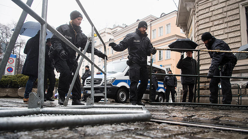 Polizisten bewegen eine Absperrung vor dem Bayerischen Hof.