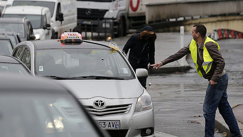 Ein Taxifahrer, der nicht am Protest teilnimmt, wird von einem Demonstraten mit Eiern beworfen. Ein Taxifahrer, der nicht am Protest teilnimmt, wird von einem Demonstraten mit Eiern beworfen.