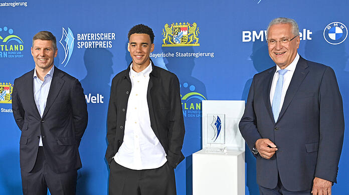 Preisgekrönter Meistertorschütze: Jamal Musiala (mi.) an der Seite von Thomas Hitzlsperger (li.) und Bayerns Innenminister Joachim Herrmann (CSU).