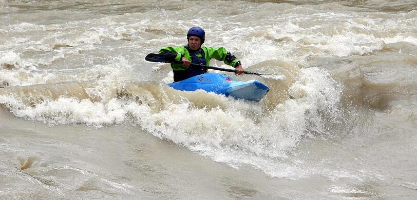 Ein Kajakfahrer auf der Isar - bei Hochwasser.