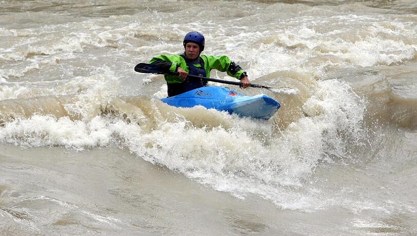 Ein Kajakfahrer auf der Isar - bei Hochwasser. Ein Kajakfahrer auf der Isar - bei Hochwasser.