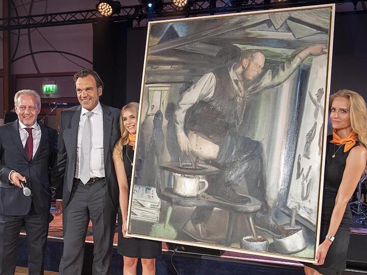 Veranstalter Steffen Göpel (l) und Unternehmer Christoph Gröner (2.v.l.), dem neuen Besitzer von Neo Rauchs Gemälde "Der Anbräuner".