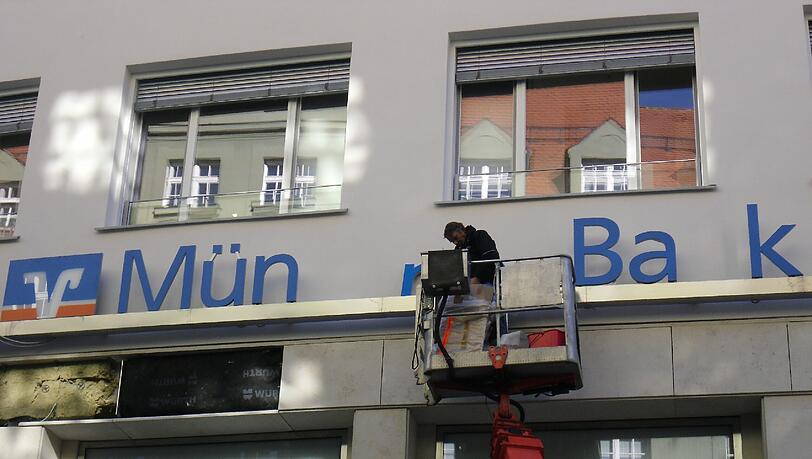 Hier wird der Schriftzug der Münchner Bank montiert. Hier wird der Schriftzug der Münchner Bank montiert.