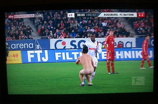 Beim Bundesliga-Derby zwischen dem FC Augsburg und dem FC Bayern München (1:2) hat am Sonntagabend ein Flitzer in der Nachspielzeit für Aufsehen gesorgt - die Bilder.