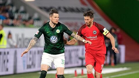 Der Wolfsburger Daniel Ginczek (l) wird von Frankfurts Kapitän David Abraham eng bewacht.