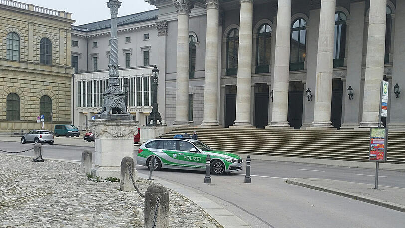 Ein Streifenwagen steht direkt vor der Oper.