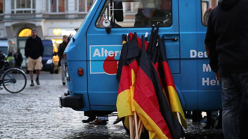 Deutschlandfahnen lehnen an einem Fahrzeug der rechtspopulistischen Partei AfD. (Symbolbild)