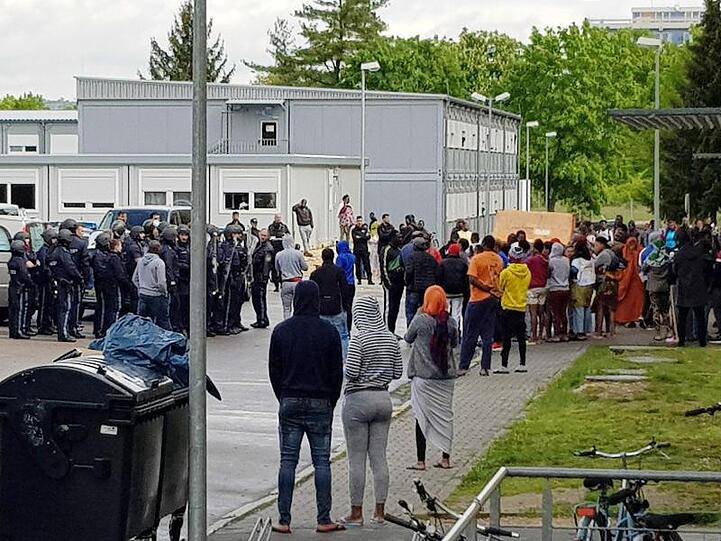 Polizisten (l) stehen vor dem sogenannten Ankerzentrum in Regensburg. Foto: Alexander Auer/Archivbild