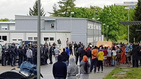 Polizisten (l) stehen vor dem sogenannten Ankerzentrum in Regensburg. Foto: Alexander Auer/Archivbild