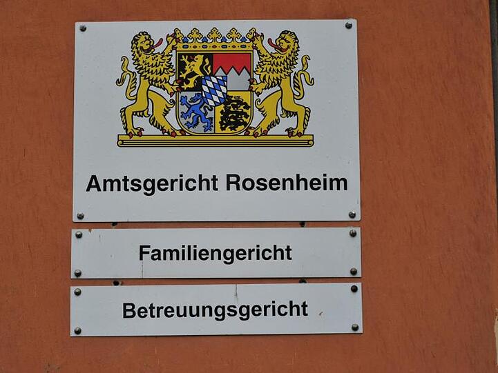 Drei Schilder: "Amtsgericht Rosenheim", "Familiengericht" und "Betreuungsgericht" hängen an einer Wand. Foto: Peter Kneffel/Archiv