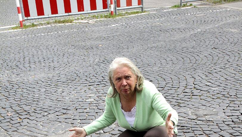 Anneliese K. zeigt das große Schlagloch, das jetzt mit Teer notdürftig zugeschüttet worden ist. Anneliese K. zeigt das große Schlagloch, das jetzt mit Teer notdürftig zugeschüttet worden ist.