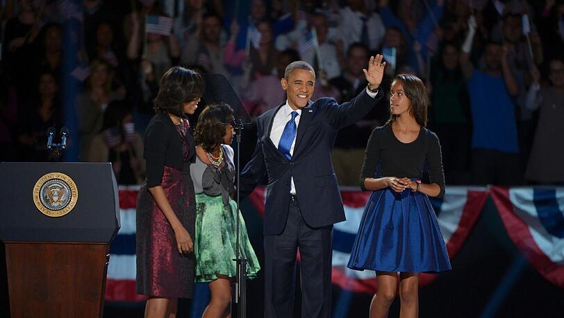 Sie bleiben die First Family: Barack Obama betritt mit Ehefrau Michelle und den Töchtern Sasha und Malia die Bühne in Chicago. Sie bleiben die First Family: Barack Obama betritt mit Ehefrau Michelle und den Töchtern Sasha und Malia die Bühne in Chicago.