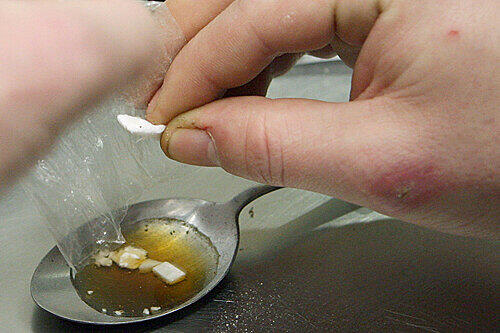 Ein Süchtiger löst in einem Esslöffel Heroin auf, um es sich danach zu spritzen. 2012 gibt es schon 22 Rauschgifttote on München