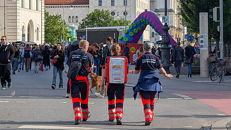 Eine Mitarbeiterin des Arbeiter-Samariterbundes im Einsatz mit zwei Kollegen des Kriseninterventionsteams bei einer Veranstaltung in München.