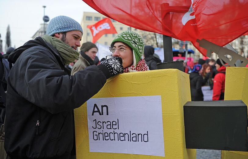 Diese Frau hat sich als Kampfflugzeug verkleidet. Von einem Mit-Demonstranten wird sie mit warmem Tee versorgt.