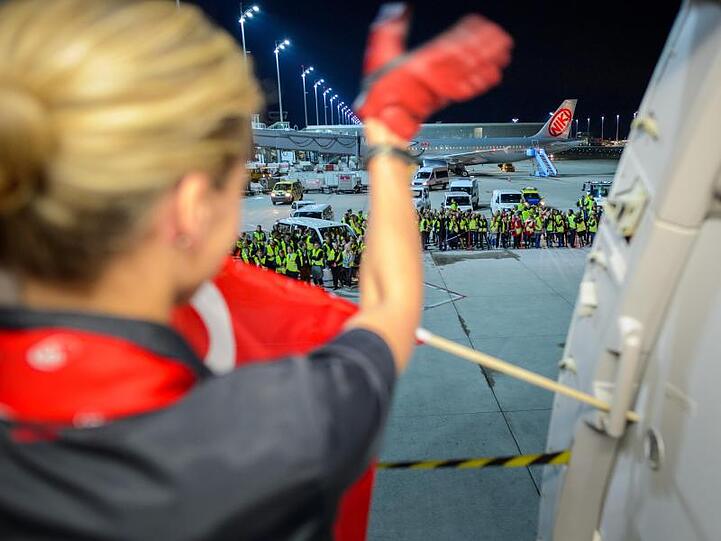 Eine Flugbegleiterin der Fluggesellschaft Air Berlin winkt am auf dem Flughafen in München weiteren Mitarbeitern der Airline vor dem letzten Flug zur Verabschiedung.