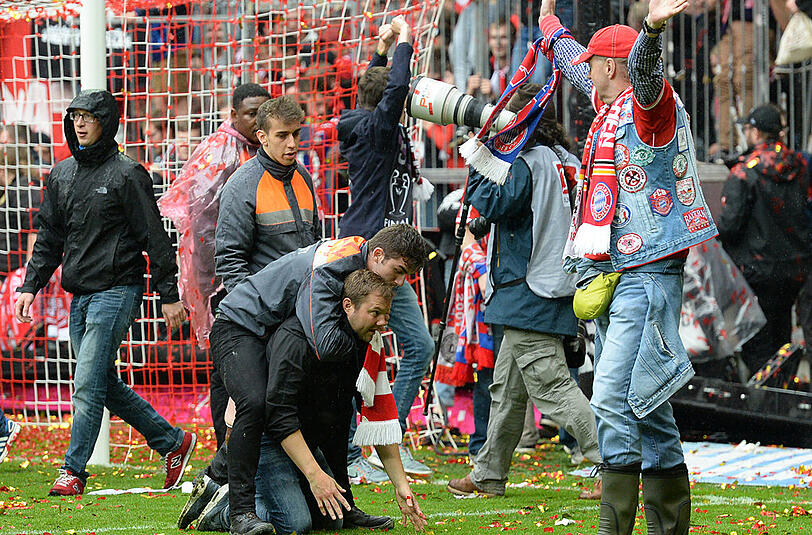 Bayern-Fans stürmen während der Meisterfeier den Rasen.