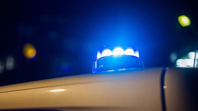 Ein Blaulicht leuchtet auf dem Dach eines Polizeifahrzeugs.