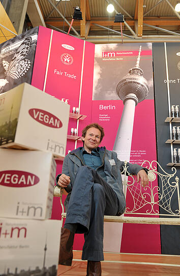Bernhard von Glasenapp, Geschäftsführer der Berliner Manufaktur I+M Naturkosmetik, vor den veganen Körperpflegeprodukten.
