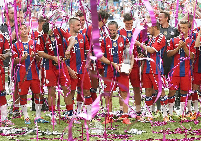 Eine Dusche aus Konfetti und Papierschlangen für die Spieler des FCB.