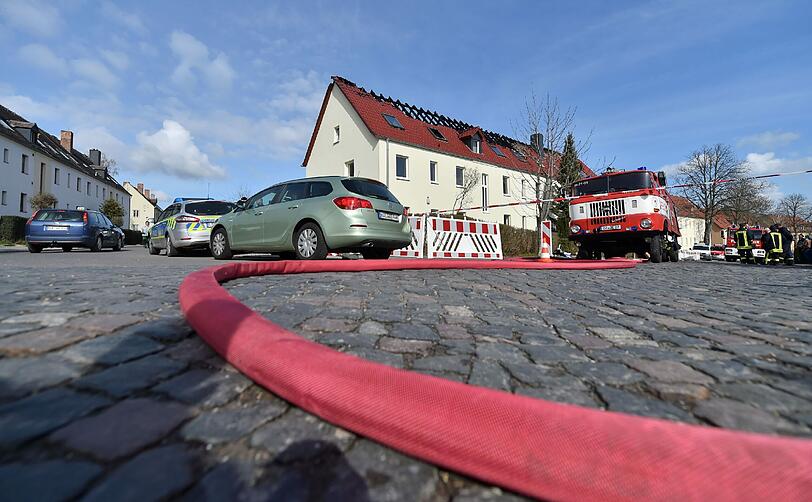 Einsatzkräfte von Feuerwehr und Polizei stehen vor der zukünftigen Unterkunft für Asylbewerber in Tröglitz.
