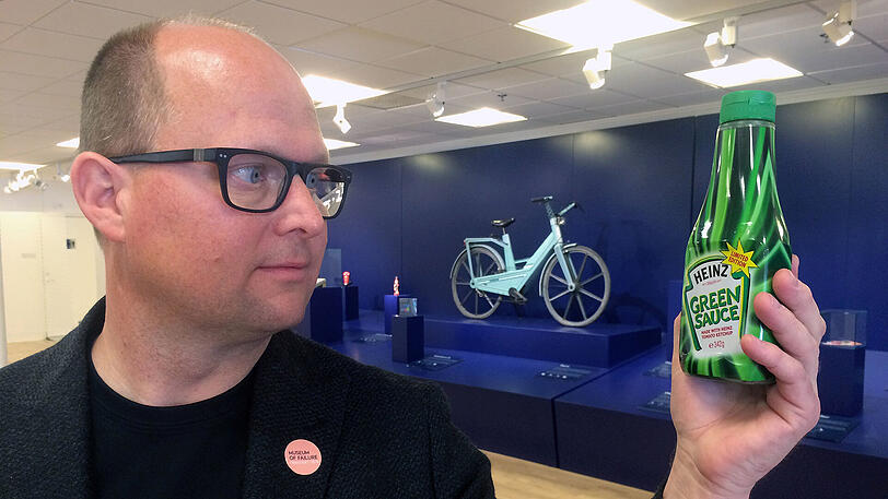 Samuel West, Kurator des "Museums des Scheiterns", hält in Helsingborg, Schweden, eine Flasche "Green Sauce"-Tomatenketchup der Firma Heinz.