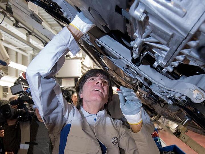 Joachim Löw einen Gelenkenwellenschutz an einen neuen Volkswagen Golf 8.