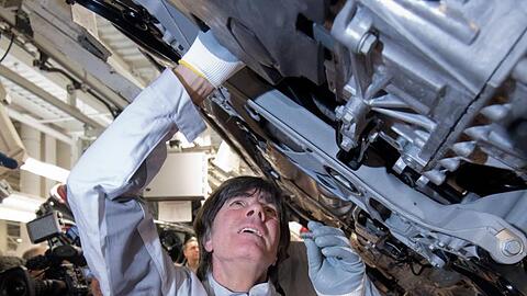 Joachim Löw einen Gelenkenwellenschutz an einen neuen Volkswagen Golf 8.
