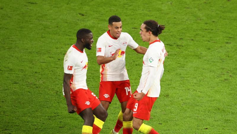 Leipzigs Yussuf Poulsen (r) bejubelt sein Tor zum zwischenzeitlichen 2:2 mit Dayot Upamecano (l) und Tyler Adams.