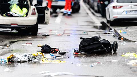 Kleidung und ein Kinderwagen liegen nach dem Anschlag auf der Straße.