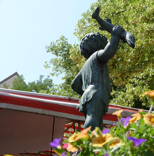 Auch der Steinbrunnen mit dem &bdquo;Brunnenbuberl&ldquo; des Bildhauers Hans Osel wird bei der Führung über den Pasinger Viktualienmarkt erläutert