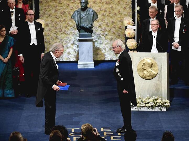Peter Handke (l) erhält den Nobelpreis von König Carl XVI. Gustaf von Schweden in der Konzerthalle in Stockholm.