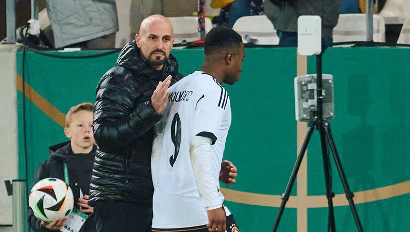 Deutschlands U21-Bundestrainer Antonio Di Salvo (l) wechselt Youssoufa Moukoko aus.